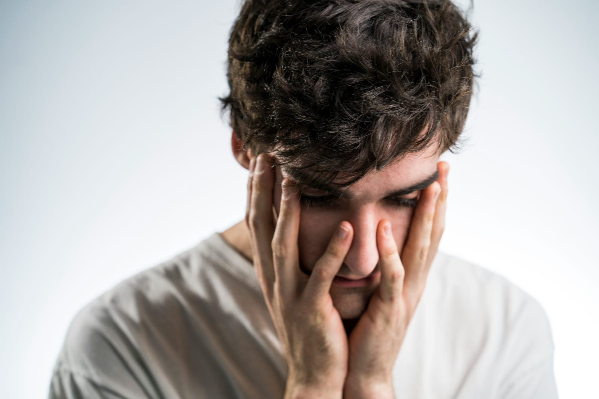 An adult sitting with his head in his hands